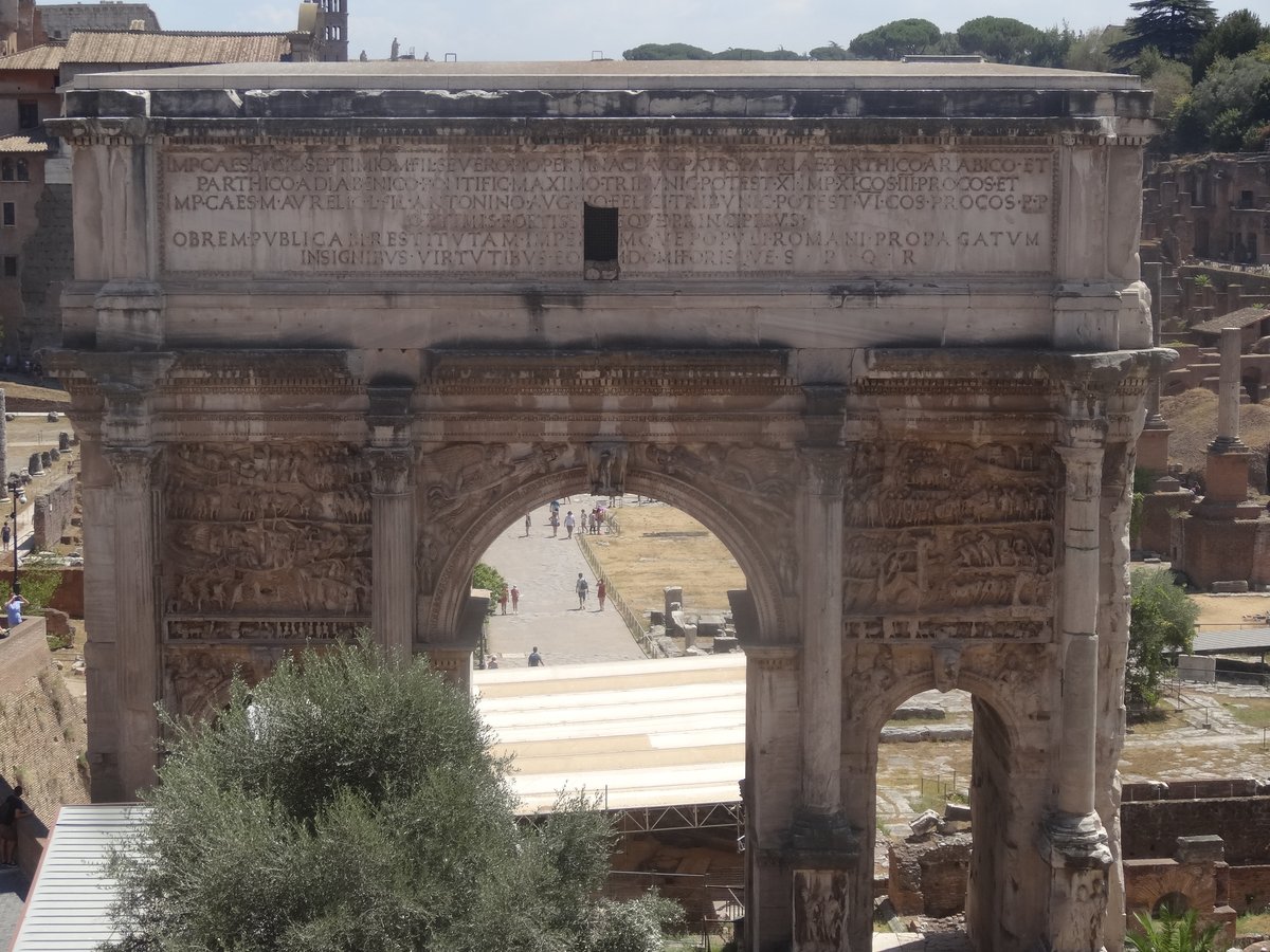 The white marble triple Arch of Septimius Severus at the edge of the Roman Forum in Rome