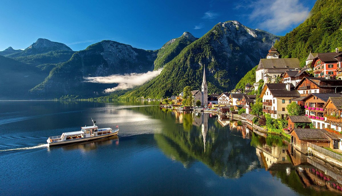 Hallstatt on its lake with a ferry and misty mountains