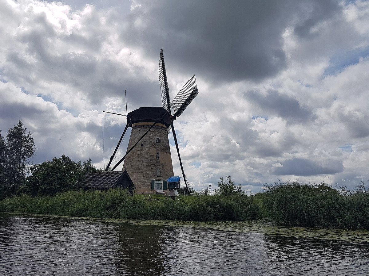 A single Kinderdijk windmill under a dramatic sky
