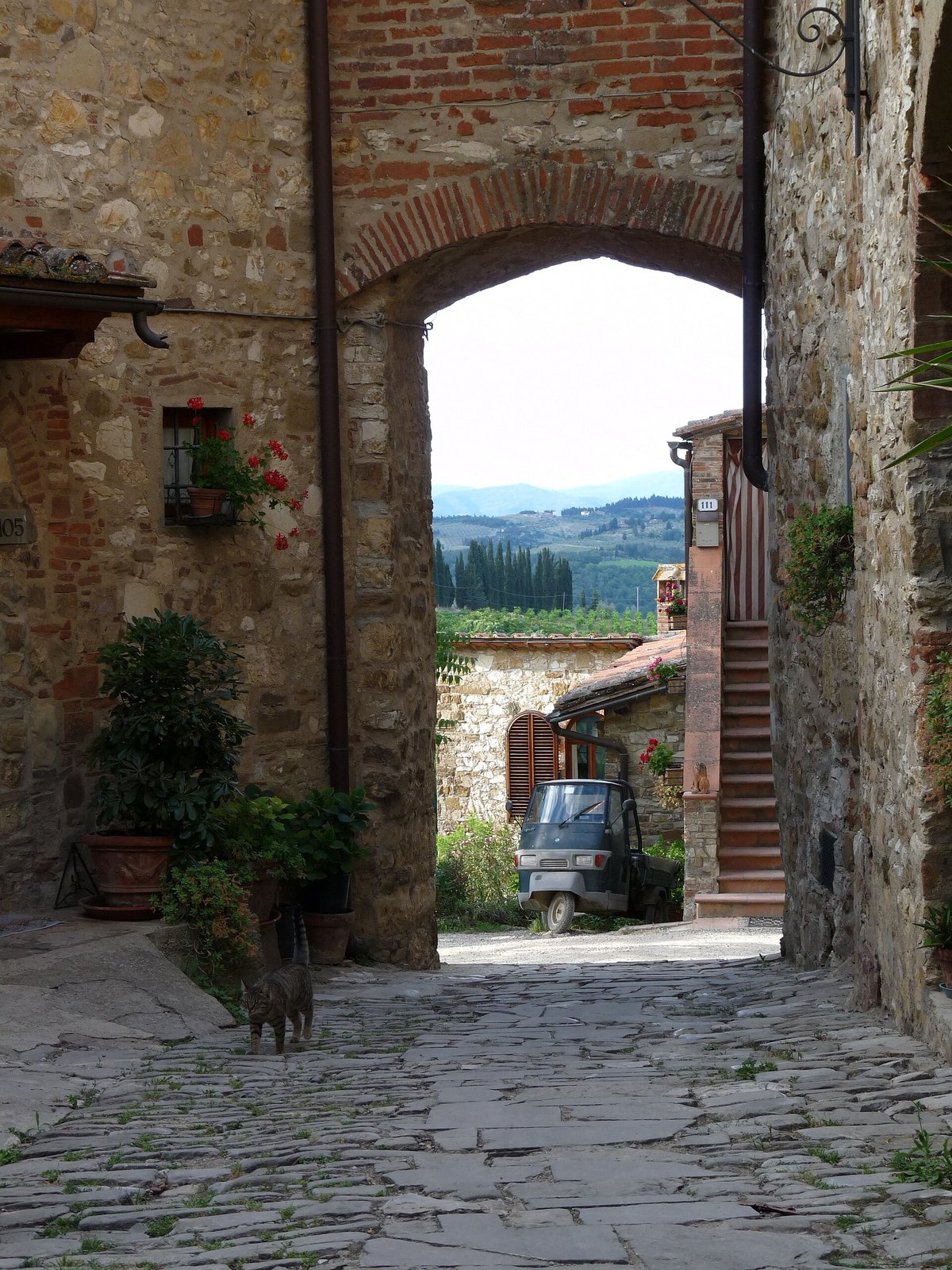 A stone gate-arch in a Chianti village opening onto the countryside