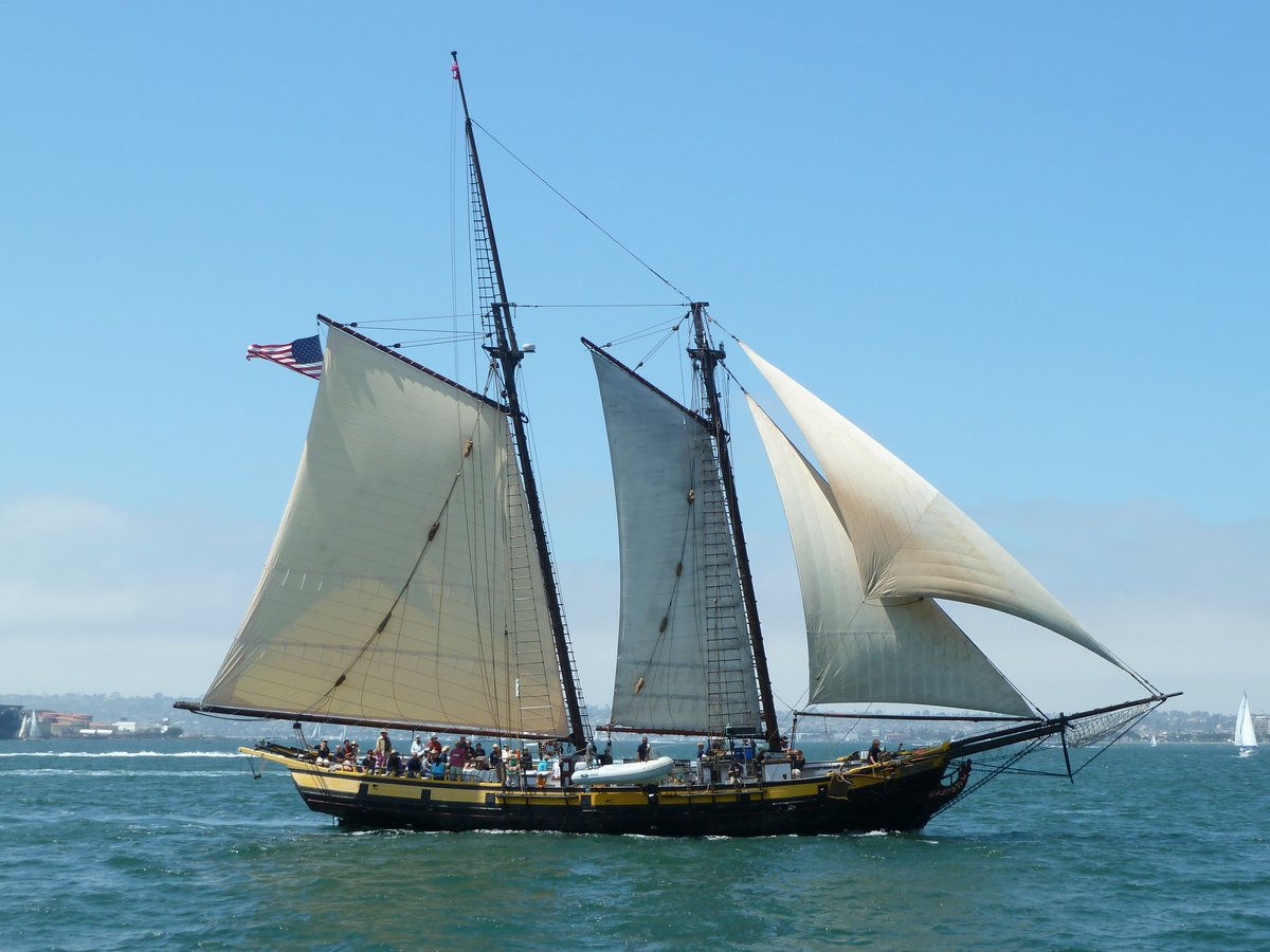 A classic two-masted wooden schooner sailing under full sail