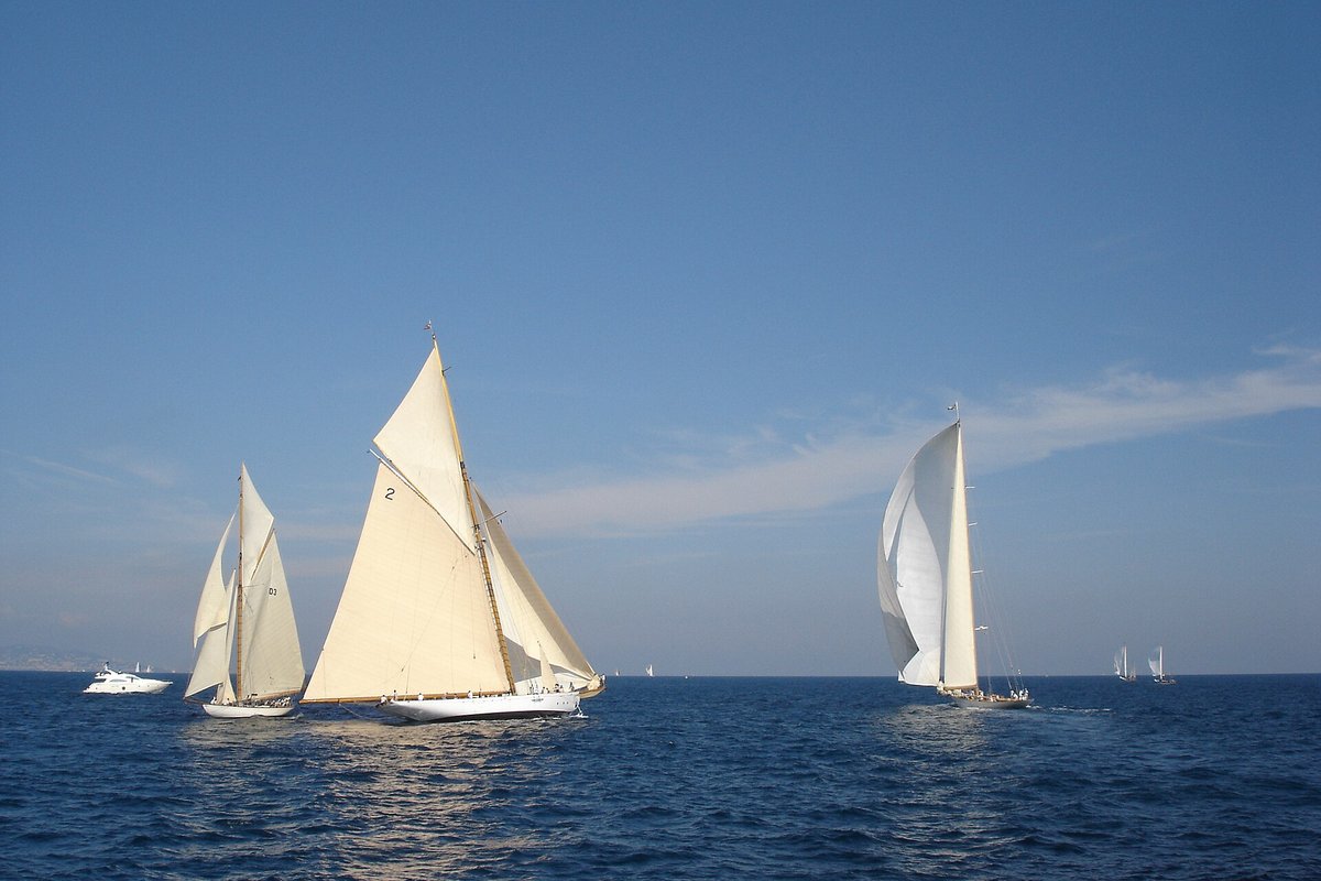Classic yachts racing under full sail on a blue sea